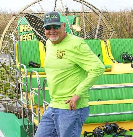 Captain John holding an alligator during a Marsh Beast Airboat Tour